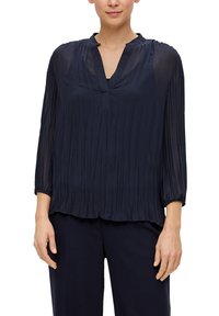 Marineblauwe geplooide blouse met een V-hals, lange mouwen en elastische manchetten. Vloeiende, lichte stof met een ontspannen pasvorm.