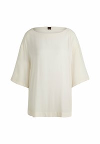 Top bianco a maniche corte con scollo ampio e vestibilità rilassata. Tessuto liscio e leggera lucentezza, con minimi dettagli di cucitura.