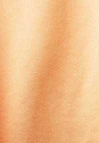 Tessuto morbido di colore pesca con una trama liscia, caratterizzato da una leggera lucentezza e un motivo a tessitura fine, adatto per abbigliamento o rivestimenti.