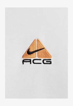 Nike ACG logo: two orange triangles with a black Nike swoosh, embroidered on white fabric. Text "ACG" in black below logo.