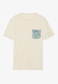 Cream-colored t-shirt with short sleeves, featuring a green floral-patterned pocket on the left side. Made of soft, lightweight fabric.