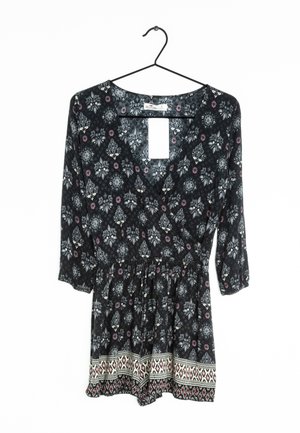 Rombière noire à fleurs avec un décolleté en V, des manches trois-quarts, une taille élastique et des garnitures décoratives présentant des motifs géométriques à l'ourlet.