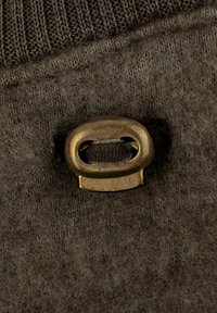 Tamno smeđa tkanina grube teksture s vertikalnim rebrastim uzorkom; sadrži mesingani prsten s pričvršćenim tekstilnim remenom.