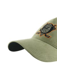 Olive green cap with a curved brim, featuring a black embroidered logo and orange accents. Soft texture with visible stitching details.