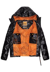 Giacca nera imbottita con interno arancione decorato con motivi a ingranaggio. Include due tasche frontali e un cappuccio con cordoncino. Etichetta del brand visibile.