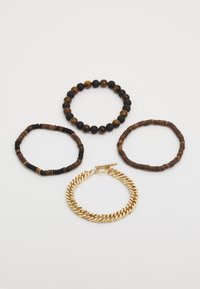 Sett med fire armbånd: to elastiske perlearmbånd i brunt og svart, ett armbånd med trepperler, og et armbånd med gullfarget kjede.