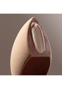 Close-up van een beige puntige schoenpunt die een getextureerde zool met een verhoogde boogondersteuning aan de binnenkant van het schoenvoorstuk toont.