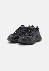 Black athletic shoes with mesh and synthetic materials, featuring textured sole, padded collar, and traditional lace-up design.