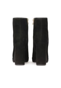Botas de tobillo de ante negro con tacón cuadrado, que cuentan con una cremallera lateral y una textura suave. Diseño cerrado con punta redondeada y silueta simple.