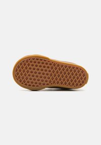 Suela de zapato de goma amarillo-marrón con un patrón texturizado en forma de hexágono. Presenta una forma redondeada y bordes lisos para una mejor tracción.