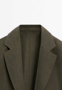 Olijfgroene linnen blazer met een Reverskraag, gestructureerde schouders en een minimalistisch ontwerp met schone stikseldetails.