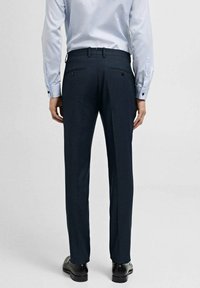Pantaloni negri închis, personalizați, cu o textură netedă, croială ajustată, talie cu bucle pentru curea și două buzunare pe spate cu butoane.