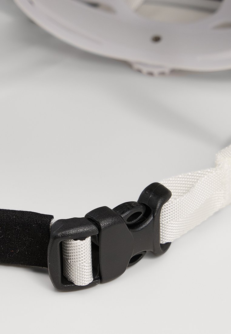 Cinghia regolabile con fibbia in plastica nera e nastro di tessuto bianco, caratterizzata da una finitura testurizzata per una migliore presa; adatta per il fissaggio di caschi.