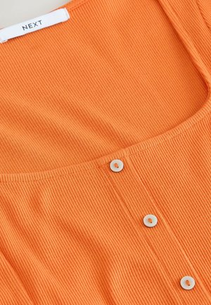 Ribbed orange top featuring a scoop neckline and white button accents along the front placket. Label shows "NEXT" at the neckline.