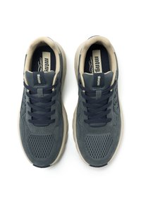 Zapatillas deportivas azul marino con parte superior de malla y acentos de ante. Cuenta con una entresuela de color crema y cordones azul marino oscuro. Plantillas de espuma para mayor comodidad.