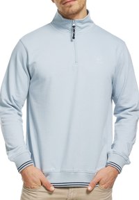 Lys blå zip-up sweatshirt med høj krave, ribbede manchetter og kant med marineblå striber. Blødt stof og subtilt logo-detalje.