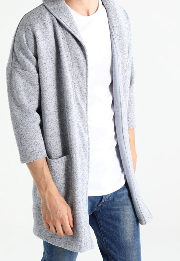 Gray knitted cardigan with a shawl collar, three-quarter sleeves, and front pockets, displayed over a white t-shirt and blue jeans.