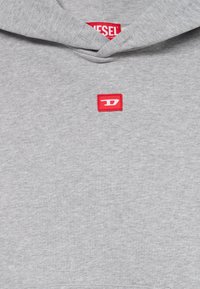 Grauer Kapuzenpullover aus weichem Stoff, mit einem roten Diesel-Logo-Patch auf der Brust. Das Design umfasst eine Kapuze und gerippte Bündchen.