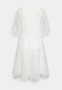 Robe en dentelle blanche avec un corsage ajusté à décolleté carré, des manches bouffantes et une jupe à volants. L'ourlet présente des motifs floraux.