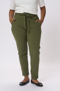 Pantalons vert olive avec une taille nouée, poches latérales et poignets retournés. Le tissu semble lisse et léger. Associés à des chaussures plates noires.
