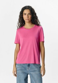 Short-sleeve pink t-shirt with a round neckline, made from smooth fabric, paired with light blue denim jeans.