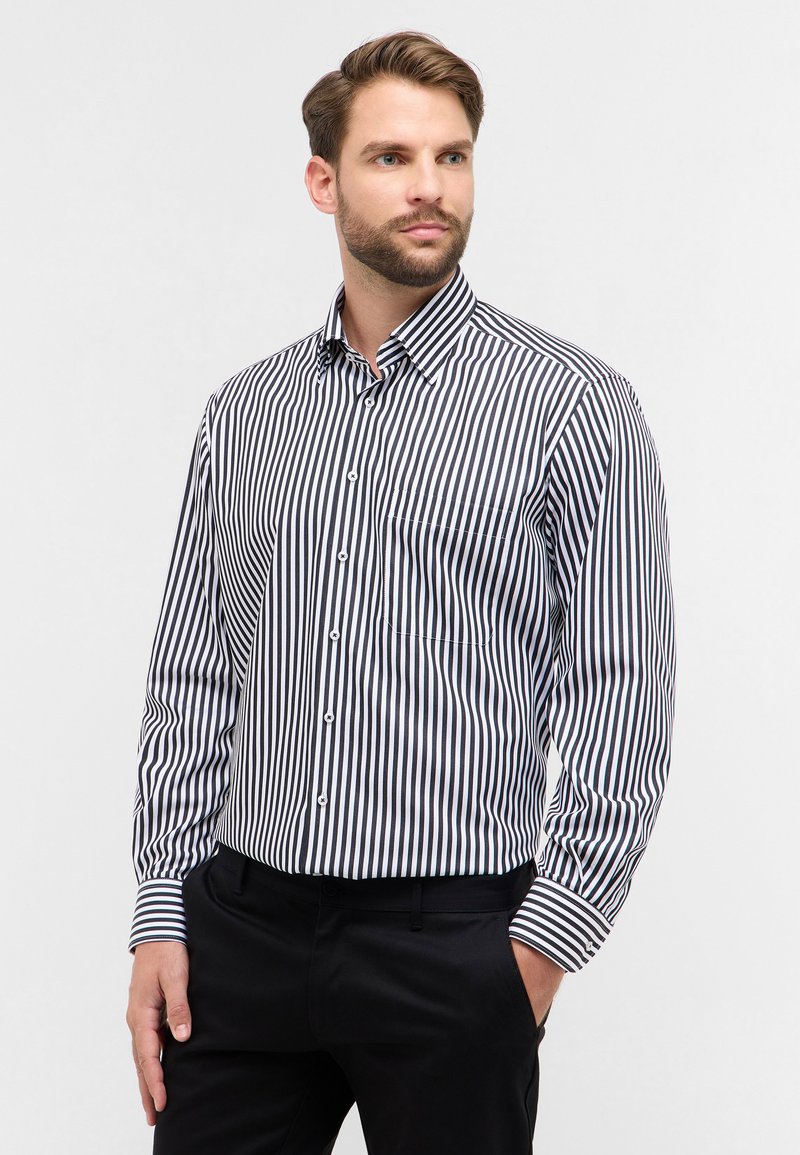 Camicia a maniche lunghe da uomo con sottili righe nere e bianche, colletto button-down, taschino sul petto e polsini a righe in contrasto.