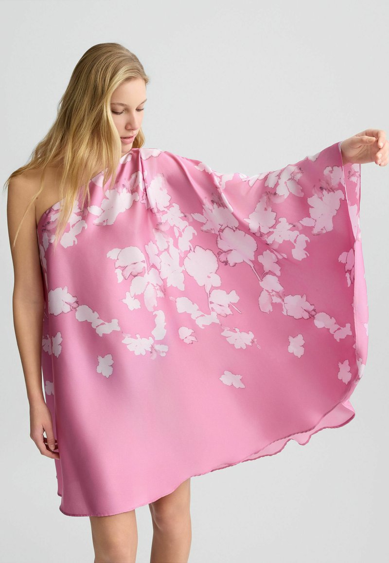 Abito in seta rosa con un design fluido, caratterizzato da motivi floreali bianchi, orlo asimmetrico, texture leggera e uno stile drappeggiato morbido.