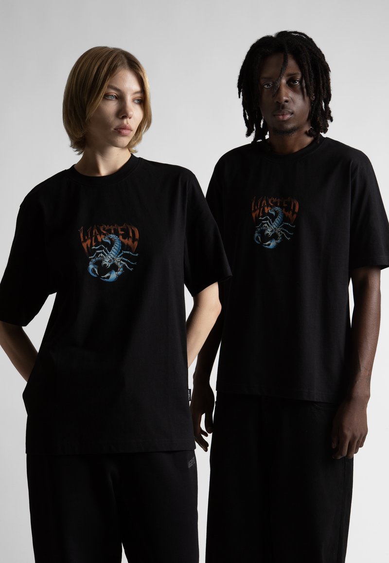 Melnas kokvilnas t-kreklu priekšpuse ir grafiskais dizains ar skorpiona attēlu un vārdu "WASTED". Kreklam ir īsas piedurknes un brīvs piegriezums.