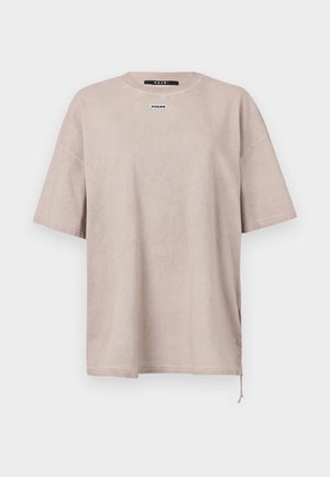 Przesadny, krótki rękaw t-shirt w jasnym beżowym kolorze wykonany z bawełny. Posiada okrągły dekolt oraz małą metkę marki na klatce piersiowej. Sznurowanie na dole.