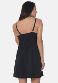 Schwarzes ärmelloses Kleid mit verstellbaren Spaghetti-Trägern, fließendem Material, A-Linien-Schnitt und glatter Textur am Rücken.