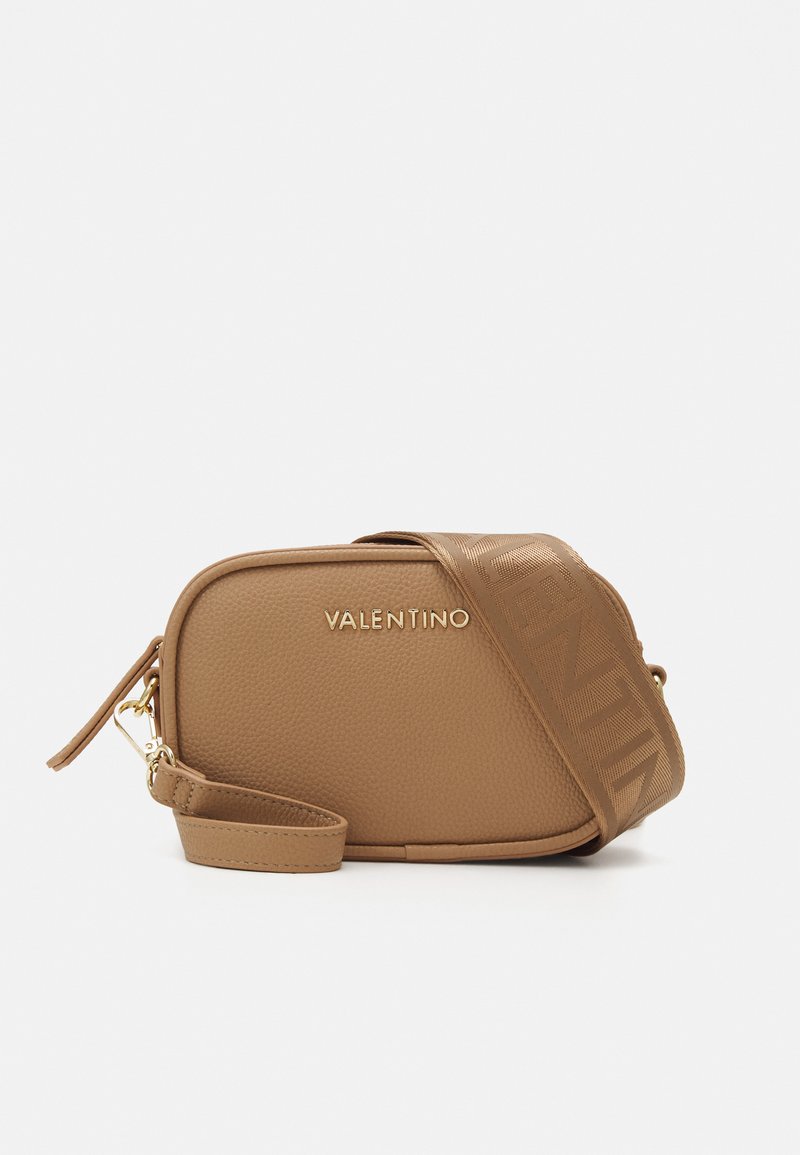 Izteikta forma, tan krāsas ādas crossbody soma ar zīmola plecu siksnu un zeltainām detaļām. Strukturēta ārpuse piešķir papildus šarmu.