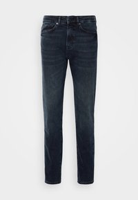 Jeans de denim ajustados de color azul oscuro con cinco bolsillos y cierre de botón y cremallera, mostrados de frente sobre un fondo blanco liso.