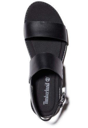 Sort lædersandal med to brede remme, en justerbar ankelspænde og en polstret fodseng med Timberland-logoet.