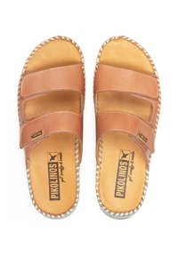 Sandalias de cuero marrón con dos correas anchas, plantilla de color natural y costuras en contraste alrededor de la suela. Diseño plano y estilo destalonado.