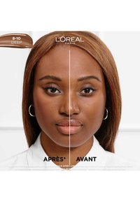 Comparaison de produits L'Oréal Paris montrant le visage d'un modèle divisé en deux : côté gauche avec un fond de teint marron clair, côté droit avec un teint naturel.