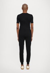 Armani Exchange TROUSER - Donji dijelovi trenirke - black/gold