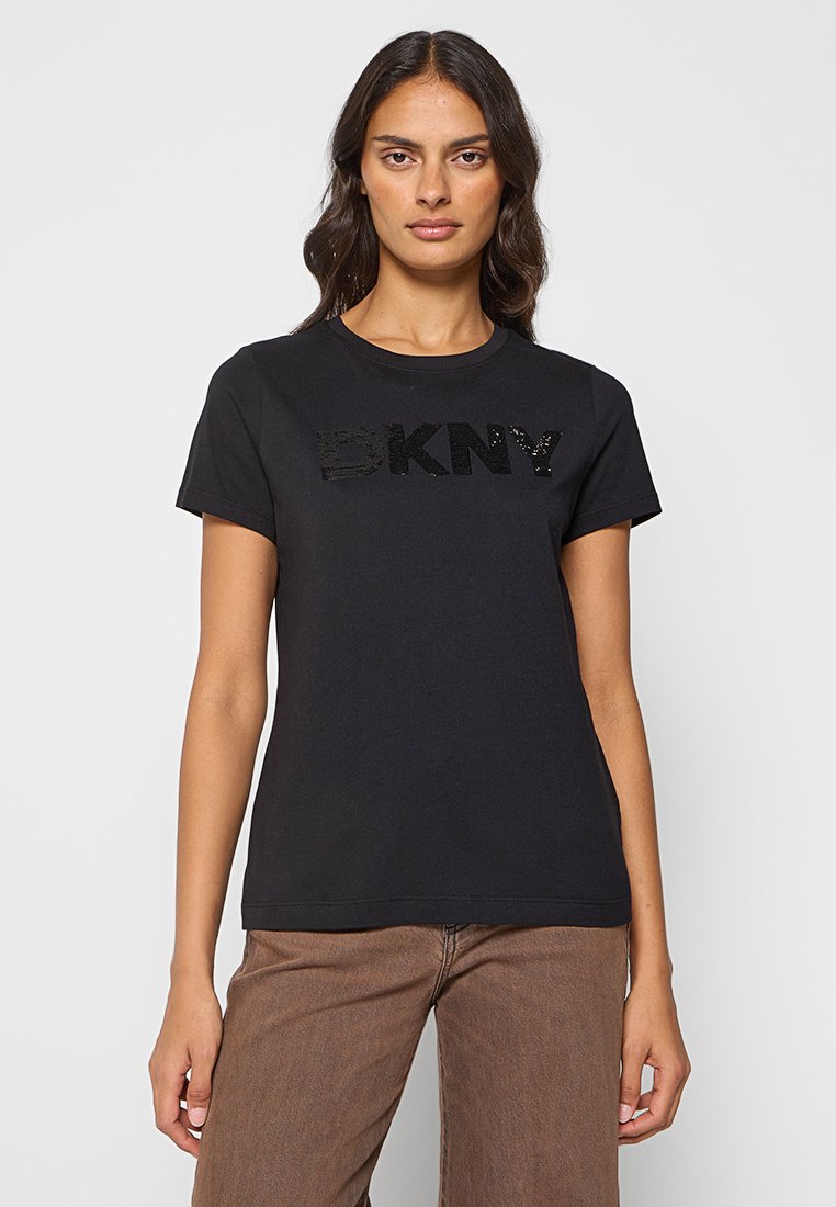 Camiseta de algodón negra con cuello redondo y mangas cortas. Con logotipo "DKNY" adornado con lentejuelas negras en el pecho.