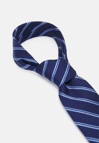 Marineblaue Krawatte mit einem strukturierten Muster, die hellblaue diagonale Streifen aufweist. Die Krawatte ist vorne gebunden, wodurch der glatte Stoff zur Geltung kommt.