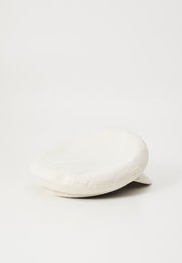 Casquette plate blanche en coton avec une texture lisse et une couronne arrondie. Elle présente un petit bord courbé et des détails cousus le long des bords.