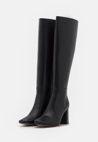 Black leather knee-high boots with a square toe and chunky heel. Smooth texture, minimal design, and a side zipper detail.
