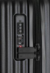 Zwarte harde koffersectie met een combinatieslot, dubbele ritssluitingen, gestructureerde ribbels en een TSA-goedgekeurd vergrendelingsmechanisme.