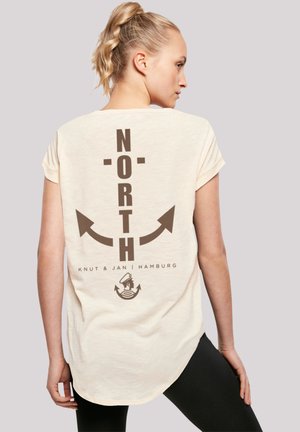 Cremefarbenes Kurzarm-T-Shirt mit braunem "NORTH"-Text und Pfeilgrafiken auf dem Rücken, mit abgerundetem Saum und weicher Textur.