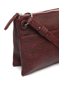 Rød lædertaske med en tekstureret overflade, der har en lynlåslukning, metalbeslag og en aftagelig rem.