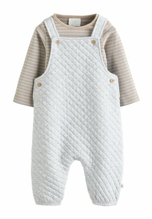 Gepolsterter grauer Overall mit Knöpfen, darunter ein gestreiftes beige-graues Langarmshirt. Weicher Stoff und elastische Bündchen an den Knöcheln.