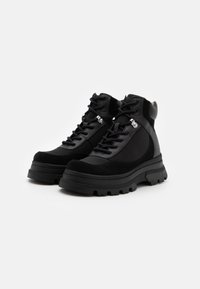 Botas altas pretas com uma combinação de pele lisa e camurça, apresentando colarinhos acolchoados, atacadores e solas de borracha espessas com cravos.