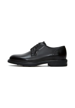 Chaussure en cuir noir à lacets avec un bout rond, texture lisse, design minimaliste et semelle en caoutchouc contrastante.