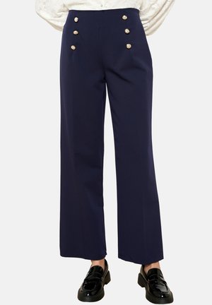 Pantalons larges navy à taille haute, ornés de boutons dorés sur le devant. Tissu lisse avec une coupe structurée.