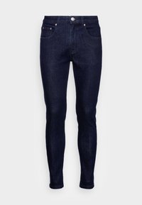 Jeans skinny de ganga azul-escuro com uma textura suave, design de cinco bolsos, fecho de correr e botão. Acentuados com detalhes em metal prateado.