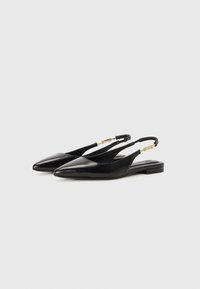 Sapatilhas pretas em couro com calcanhar aberto, com bico afinado, design minimalista e detalhes em metal dourado no fecho ajustável.