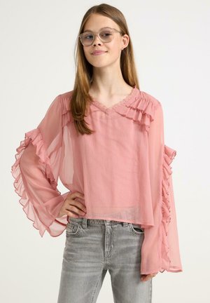 Lyserød ruffle-bluse med lange, luftige ærmer og v-udskæring; letvægts- og gennemsigtigt stof med en tekstureret finish, parret med grå jeans.